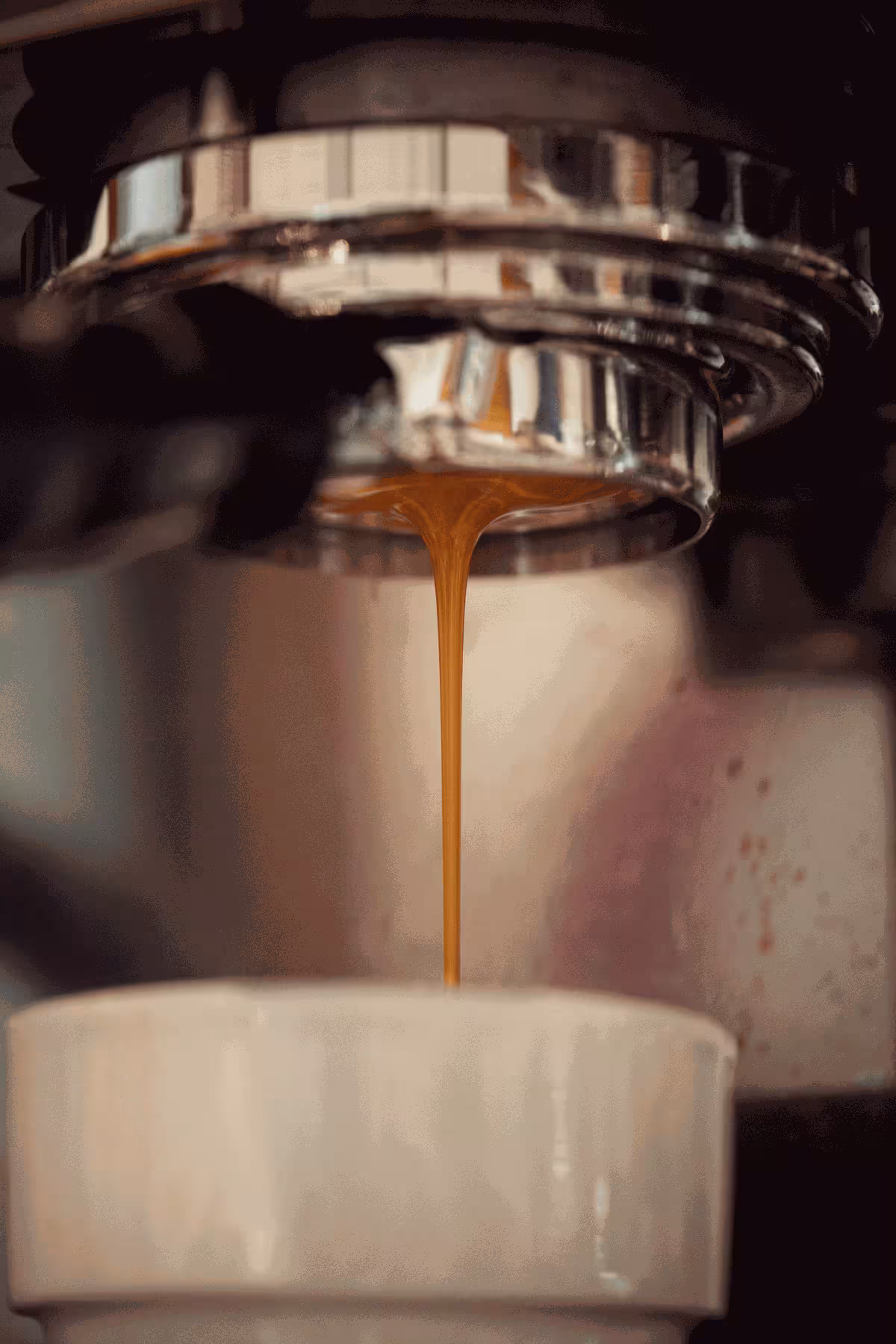 Portafilter, aus dem frisch extrahierter Espresso in eine Tasse tropft